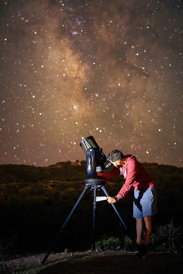 Michalis Reisis hosting a stargazing event with telescope under the Milky Way